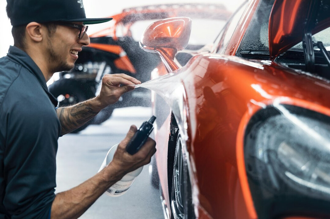 Auto body technician inspecting a car for rust spots